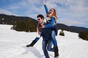 glückliches junges paar, das spaß auf frischer show im winterurlaub hat foto