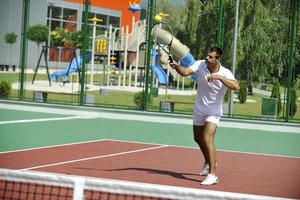 junger Mann spielt Tennis im Freien foto