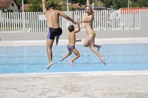 glückliche junge familie hat spaß am schwimmbad foto