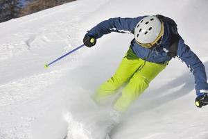 Skifahren auf Neuschnee in der Wintersaison am schönen sonnigen Tag foto
