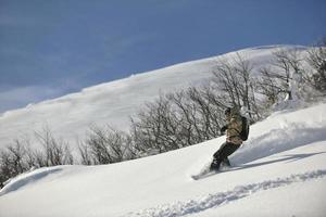 Freestyle-Snowboarder springen und fahren foto