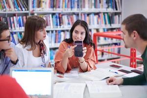 studentengruppe, die gemeinsam an einem schulprojekt auf einem tablet-computer an einer modernen universität arbeitet foto