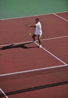 junger mann spielt tennis foto