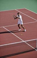 junge Frau spielt Tennis im Freien foto