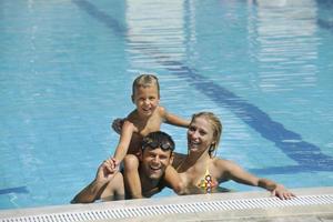 glückliche junge familie hat spaß am schwimmbad foto