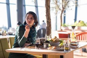 junge Frau, die im Restaurant zu Mittag isst foto