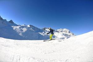 Skifahren auf Neuschnee in der Wintersaison am schönen sonnigen Tag foto