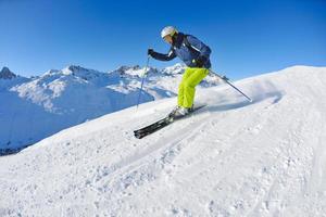 Skifahren auf Neuschnee in der Wintersaison am schönen sonnigen Tag foto