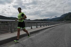 Triathlonsportler, der auf der Straße läuft foto