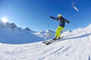 Skifahren auf Neuschnee in der Wintersaison am schönen sonnigen Tag foto