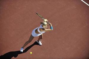 junge Frau spielt Tennis im Freien foto