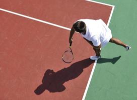 junger Mann spielt Tennis im Freien foto