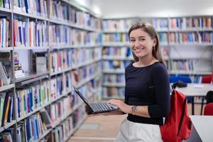 der Schüler benutzt ein Notizbuch und eine Schulbibliothek foto