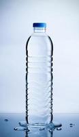 Reine Wasserflasche aus Kunststoff mit Wassertropfen auf dem Tisch, Gesundheits- und Beauty-Hydrationskonzept foto