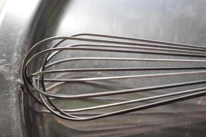 manueller handmixer zum mischen, schlagen, eierschläger isoliert auf metallhintergrund. Küchenutensilien aus Metall und Edelstahl. foto