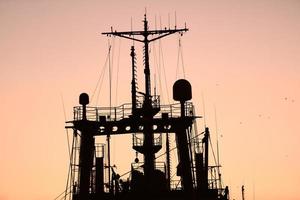 Silhouetten von Schiffen und Containerkränen im Seehafen foto