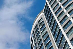 Büro-Wolkenkratzer hohes Geschäftsgebäude auf blauem Himmelshintergrund, mit Blick auf ein modernes Glasgebäude foto