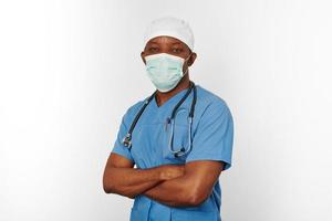 schwarzer chirurg arztmann im blauen mantel weiße kappe und chirurgenmaske isoliert auf weißem hintergrund foto
