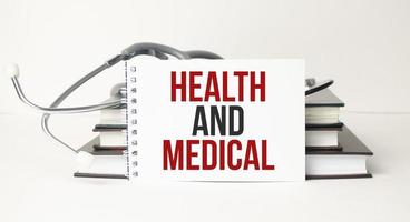Gesundheit und medizinische Wörter auf Notizblock und Stethoskop foto