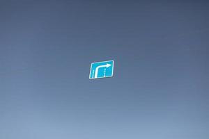rechtes Abbiegezeichen. Straßenschild über der Straße. blaues Schild mit Pfeil gegen den Himmel. foto