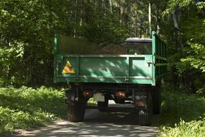 Traktor-Anhänger. Wagen für LKW. Auto fährt durch Park. foto