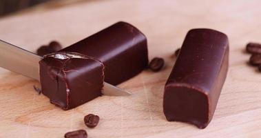Gekühlten Hüttenkäse mit Zucker in Schokolade schneiden foto