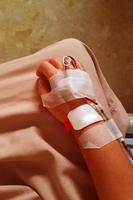 unscharfes bild einer patientenhand mit iv-schlauch zur bluttransfusion in nahaufnahme. foto