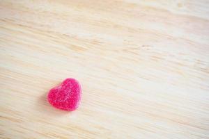 rosa Herzen Süßigkeiten auf Holz für Valentinstag Hintergrund foto