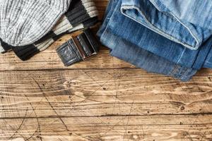 Jeanskleidung und Accessoires auf braunem Holzhintergrund foto