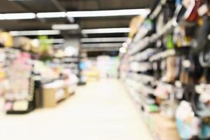 Abstrakter unscharfer Supermarkt mit antihaftbeschichteter Pfanne auf den Regalen der Küchenutensilien im Lebensmittelgeschäft mit defokussiertem Hintergrund foto