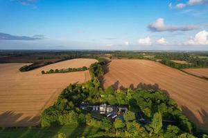 Blick aus der Vogelperspektive auf Kühe, die auf dem Feld gegen den Himmel grasen. Wunderschöne, hochwinkelige Luftaufnahme der Tierfarm auf dem britischen Landwirtschaftsfeld in der Nähe von London, England, Großbritannien, Großbritannien foto