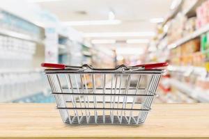 leerer Einkaufskorb auf Holztisch über Lebensmittelgeschäft Supermarkt verwischen Hintergrund foto