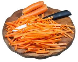 geschnittene Karotte und Keramikmesser auf Schneidebrett foto