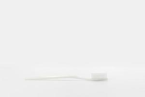 Isolierte einfache normale weiße Zahnbürste wird im Studiolicht auf den weißen Hintergrund gelegt. Beschneidungspfad. foto