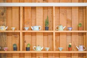 Teekanne zu Baumtopfdekoration in Holztisch und Regal im asiatischen Garten. foto