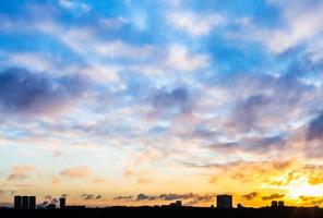 sonnenuntergangshimmel mit wolken über städtischen häusern im winter foto