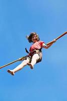 Mädchen springt auf Bungee-Seil foto