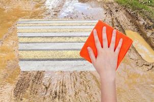 Hand löscht Becher auf Landstraße durch orangefarbenes Tuch foto