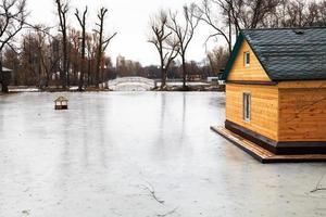 Teich mit Steg und Haus am Wintertag foto