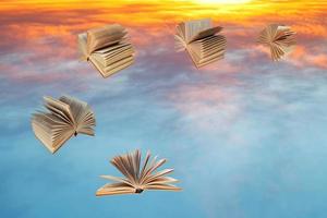 Bücher fliegen über Sonnenuntergangswolken foto