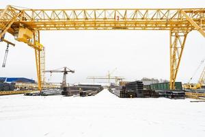 Landschaft mit Brückenkränen und Metallprodukten foto