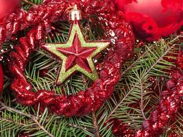 roter Stern, Lametta auf Weihnachtsbaumhintergrund foto