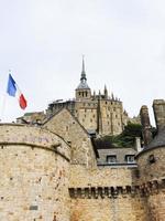 Flagge und Abtei Mont Saint-Michel in der Normandie foto