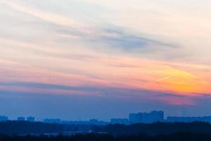 früher blauer Sonnenaufgang unter der Stadt foto