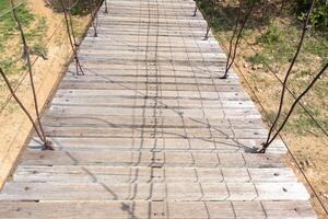 Auf dem Boden schwimmende Hängebrücke aus Holz. foto