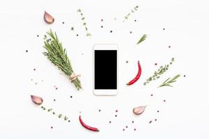 Smartphone mit grünen Kräutern und Gewürzen herum foto