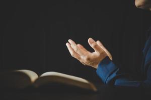 Hand gefaltet im Gebet zu Gott auf heiligem Bibelbuch im Kirchenkonzept für Glauben, Spiritualität und Religion, Frau, die morgens auf heiliger Bibel betet. christlich-katholische frauenhand mit bibelanbetung. foto