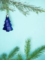 Weihnachtsbaumspielzeug auf blauem Hintergrund. die Äste fraßen. Karte foto