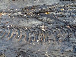 Radspuren von schweren Maschinen auf nassem Boden. Traktorreifenspur foto