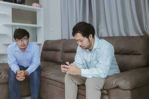 asiatische homosexuelle paare streiten, wütend oder traurig auf dem sofa zu hause, lgbtq-konzept. foto